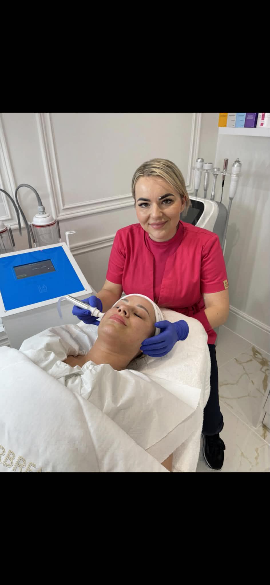 Natalia performing a Hydrafacial treatment on a client at Gingerbread Aesthetic, Towcester, with the Hebe hydrogen water machine visible